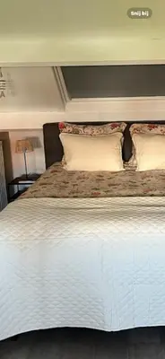 a large white bed with two pillows on it at Zon & blij in Katwijk aan Zee