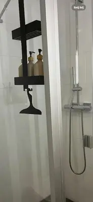 a bathroom with a shower and a shelf with jars at Zon & blij in Katwijk aan Zee