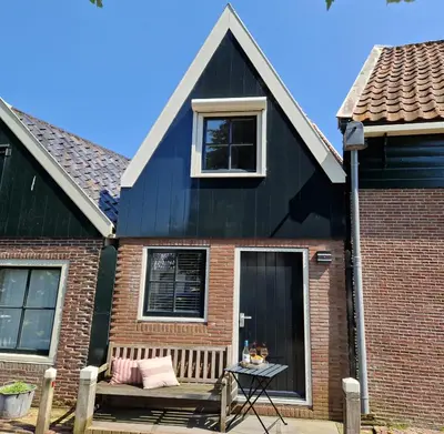 a black house with a bench and a window at Bed & Breakfast De Punt in Monnickendam