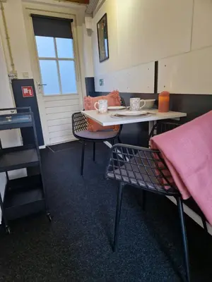 a room with a table and two chairs and a table at Bed & Breakfast De Punt in Monnickendam