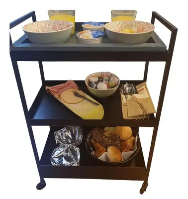 a food cart with bowls and other food items on it at Bed & Breakfast De Punt in Monnickendam