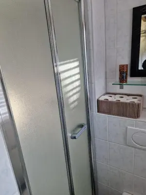 a shower with a glass door in a bathroom at Bed & Breakfast De Punt in Monnickendam