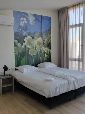 a bedroom with a bed with a painting on the wall at Blom studio's in Hillegom