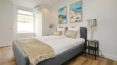 a bedroom with a large bed with a window at Steenhof Beach House in Noordwijk