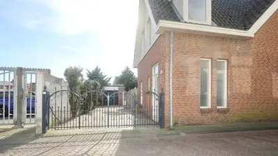 a brick building with a gate in front of it at Steenhof Beach House in Noordwijk