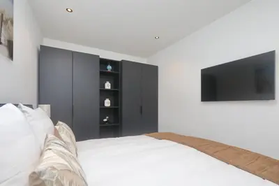 a bedroom with a bed with a tv on the wall at Steenhof Beach House in Noordwijk