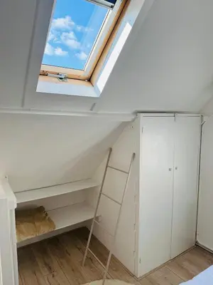 a skylight in a loft conversion with a window at Zeeschelpje in Noordwijk aan Zee