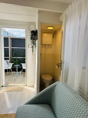 a living room with a couch and a door to a patio at Zeeschelpje in Noordwijk aan Zee