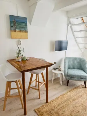 a dining room with a wooden table and chairs at Zeeschelpje in Noordwijk aan Zee