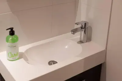 a bathroom sink with a green soap bottle on it at Lovely 4P-apt near Canals - Utrecht City Centre in Utrecht