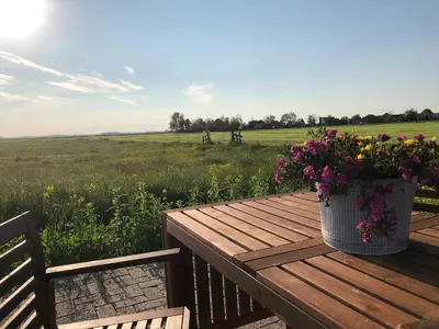 a bucket of flowers sitting on a wooden table at BB Saari in De Woude