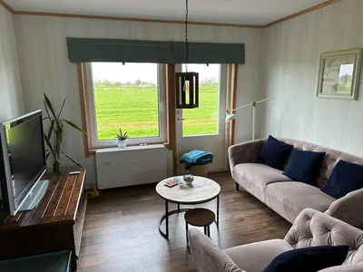 a living room with a couch and a tv at BB Saari in De Woude
