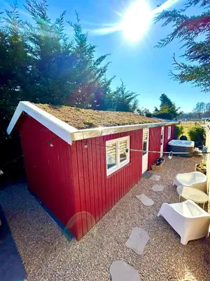 a red building with two toilets in a yard at New Charming Scandinavian eco house with garden and jacuzzi in Vijfhuizen