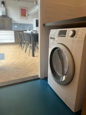 a washing machine in a room with a kitchen at Wellness Appartement Duinpoort in Castricum