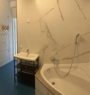 a bathroom with a sink and a bath tub and a sink at Wellness Appartement Duinpoort in Castricum