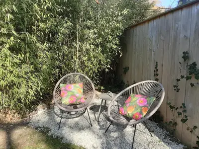 two chairs with pillows sitting in a yard at studio Le Garage in Bergen