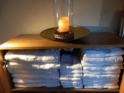 a candle sitting on top of a table with towels at studio Le Garage in Bergen