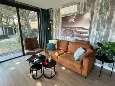 a living room with a couch and a table at BeachHouse AAN ZEE in Noordwijk aan Zee