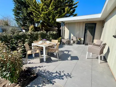 a patio with a table and chairs on a sidewalk at BeachHouse AAN ZEE in Noordwijk aan Zee