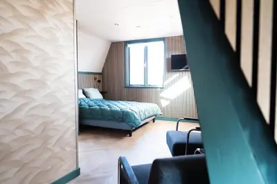 a bedroom with a bed and a mirror at 1 aan Strand in Egmond aan Zee