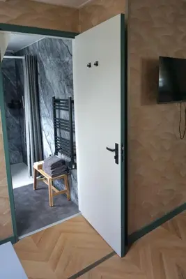 a door leading into a room with a mirror at 1 aan Duin in Egmond aan Zee