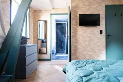 a bedroom with a bed and a television on a wall at 1 aan Duin in Egmond aan Zee
