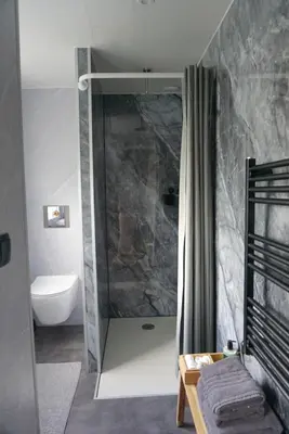 a bathroom with a shower with a toilet and a sink at 1 aan Duin in Egmond aan Zee