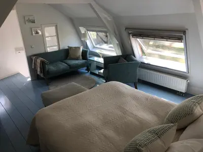 a living room with a couch and a chair at De Vink Bed & Breakfast in Abcoude