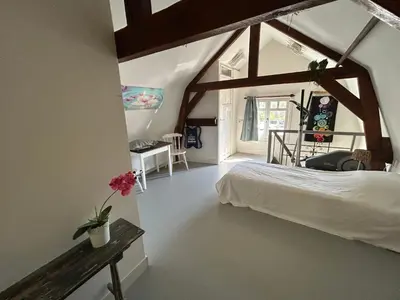 a bedroom with a white bed and a window at Het Koetshuis in Gouda