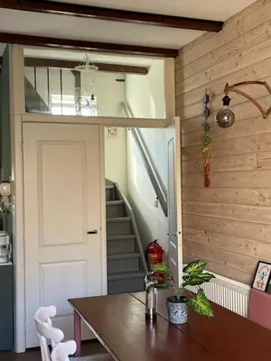 a room with a door and a table and a staircase at Het Koetshuis in Gouda