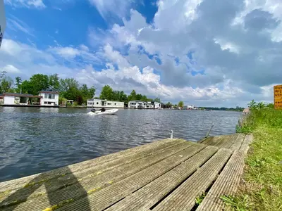 a boat is on the water near a dock at Holiday Home Vijfhuizen 2pers in Vijfhuizen