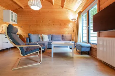 a living room with a blue couch and a table at Chalet Zandvoort in Zandvoort