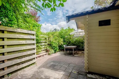 a backyard with a table and a wooden fence at Chalet Zandvoort in Zandvoort