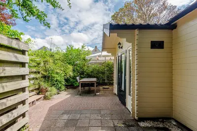 a patio with a table next to a house at Chalet Zandvoort in Zandvoort