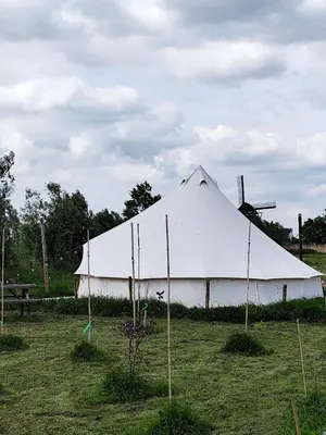a large white tent in the middle of a field at Voedselbos Camping Koperwiek in Hazerswoude-Dorp