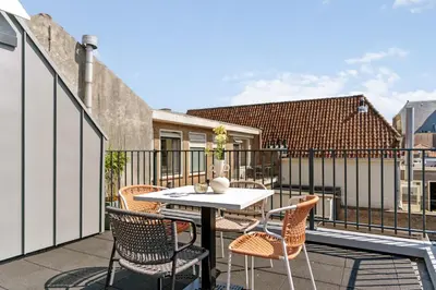 a patio with a table and chairs on a balcony at STONEBRIDGE boutique apartments - City centre in Alkmaar