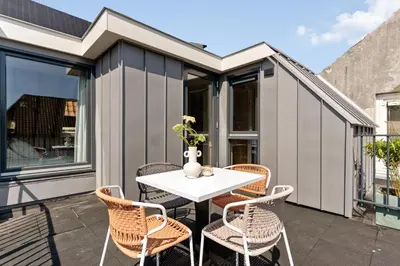 a patio with a white table and chairs at STONEBRIDGE boutique apartments - City centre in Alkmaar