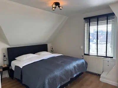 a bedroom with a large bed and a window at Sunny Beach in Zandvoort