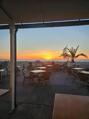 a group of tables and chairs on the beach at sunset at Sunny Beach in Zandvoort