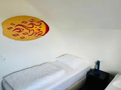 a bedroom with a bed with a sign on the wall at Villa Harry aan Zee in Egmond aan den Hoef