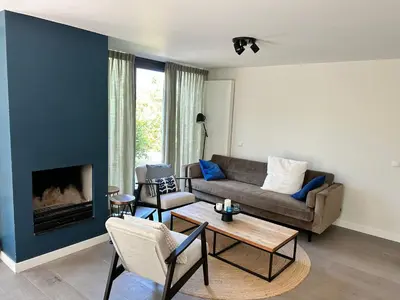 a living room with a couch and a fireplace at Villa Harry aan Zee in Egmond aan den Hoef