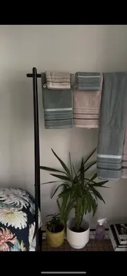 a bedroom with a plant and towels on a wall at Apartment in Oude-Pijp in Amsterdam