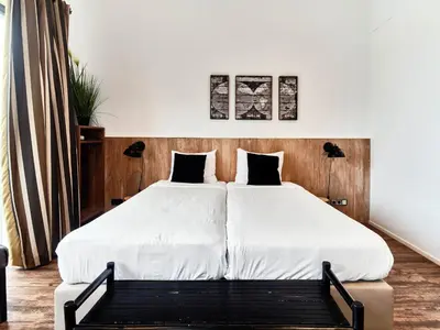 a bedroom with a large bed with white sheets at Hajé Restaurant de Aalscholver in Lelystad