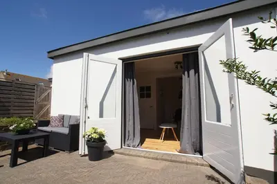 an open door to a garden room with a patio at Zomerhuis aan Zee in Zandvoort
