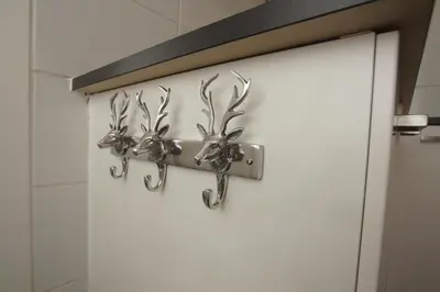 a pair of deer head wall hooks on a bathroom door at Zomerhuis aan Zee in Zandvoort