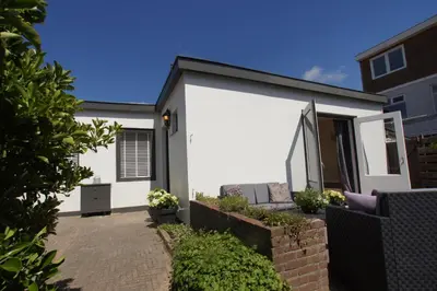 a white house with a patio in front of it at Zomerhuis aan Zee in Zandvoort
