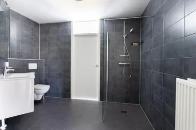 a bathroom with a shower and a toilet at Gezellig 2 kamerappartement in Burgerbrug Dicht bij strand en natuur! in Burgerbrug