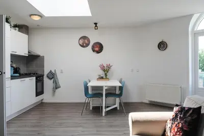 a kitchen and dining room with a table and chairs at Gezellig 2 kamerappartement in Burgerbrug Dicht bij strand en natuur! in Burgerbrug