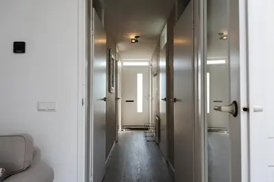 a hallway with a long corridor with white walls at Gezellig 2 kamerappartement in Burgerbrug Dicht bij strand en natuur! in Burgerbrug