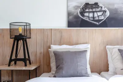 a bedroom with a bed and a picture of a boat at Hajé Hotel Restaurant de Lepelaar in Lelystad